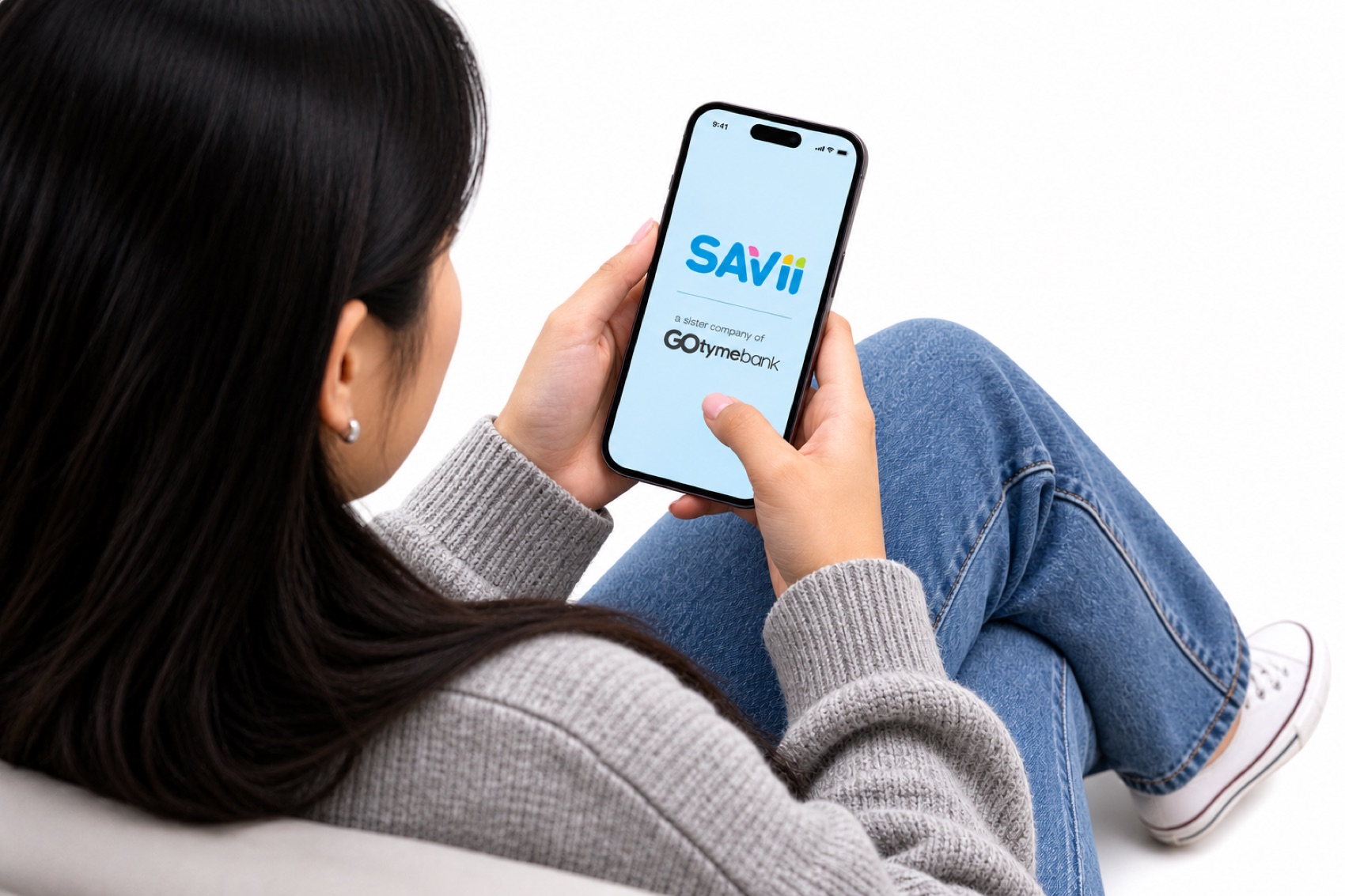 A SAVii customer holding a phone showing the SAVii app home screen.